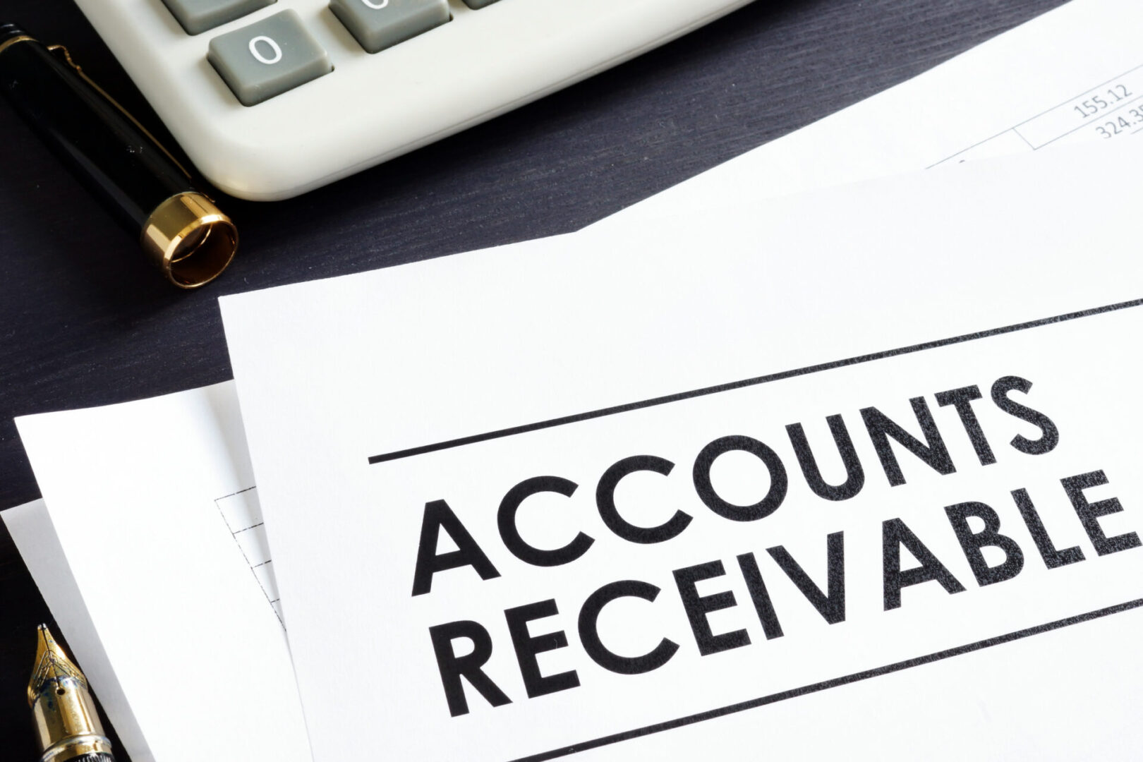Accounts receivable document with calculator, pen.