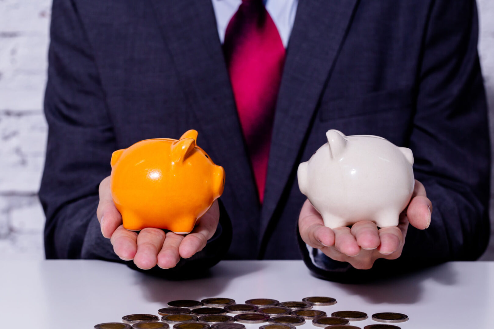 Man holding orange and white piggy banks.