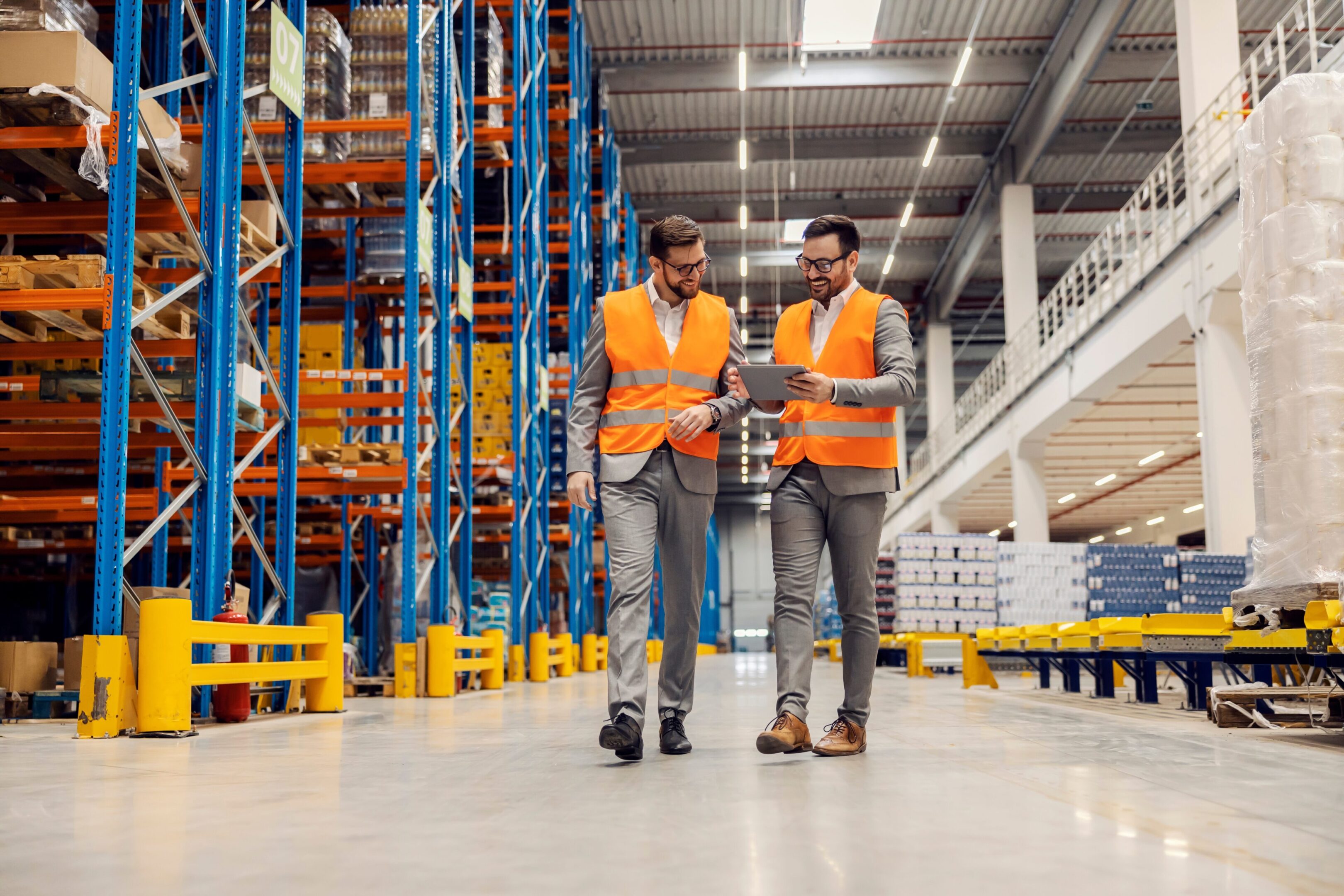Businesspeople,Dispatching,Warehouse,And,Smiling,At,The,Tablet.