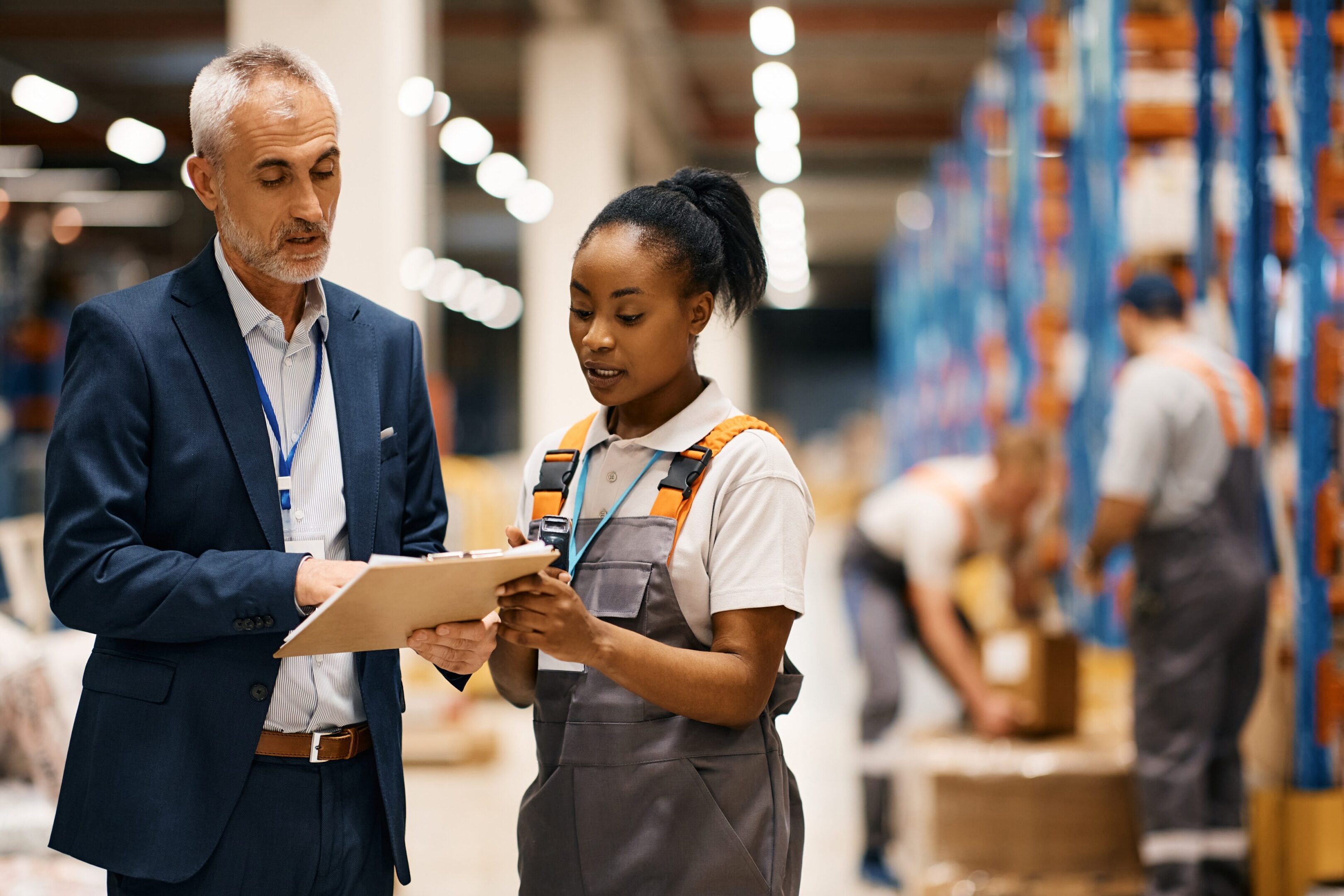 African,American,Warehouse,Worker,And,Her,Supervisor,Cooperating,While,Analyzing